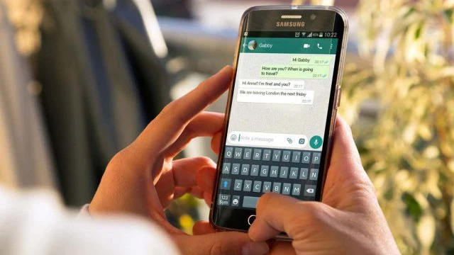 Icona di WhatsApp su uno schermo con segnali di avviso sicurezza